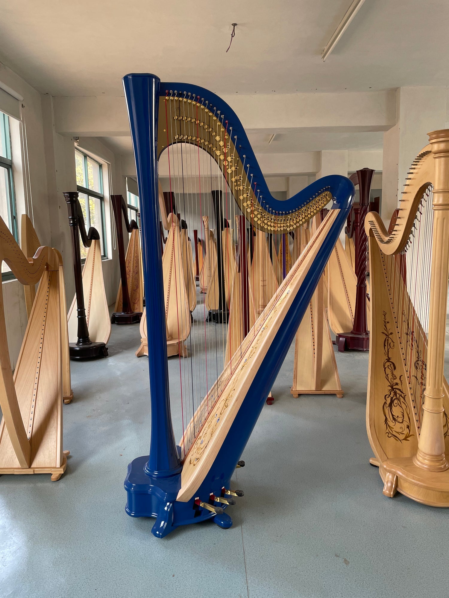 Harp with blue neck and wooden body on a reflective surface